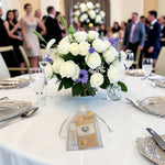 Cadeau invité mariage personnalisé présenté sur une table de réception, avec baume à lèvres artisanal à la cire d'abeille, sachet de graines personnalisé et pochon en organza.