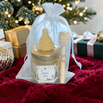 Coffret cadeau de Noël artisanal composé d'un mini pot de miel, d'une bougie en cire d'abeille et d'une cuillère à miel en bois, idéal pour les cadeaux de fin d'année et les remerciements.
