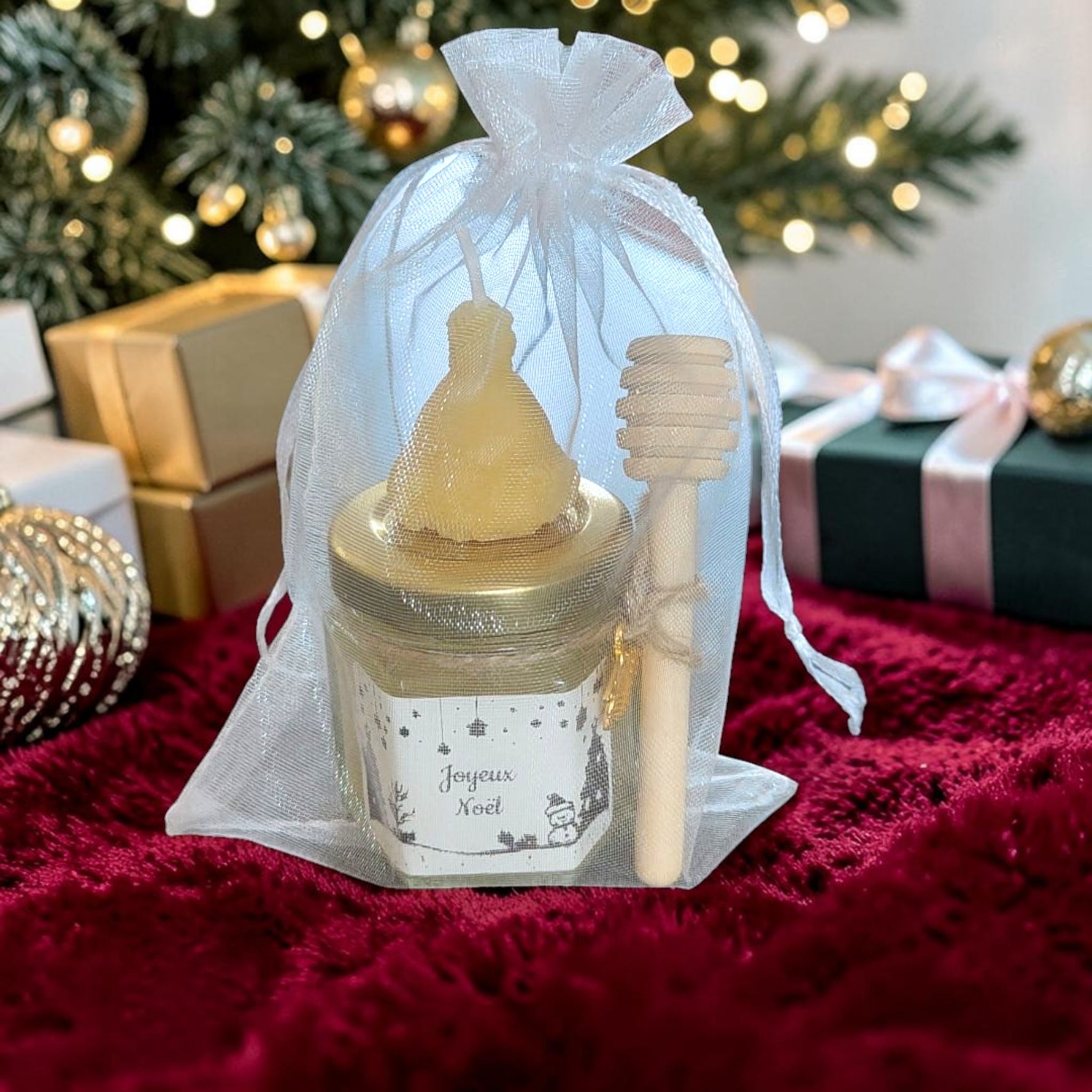 Coffret cadeau de Noël artisanal composé d'un mini pot de miel, d'une bougie en cire d'abeille et d'une cuillère à miel en bois, idéal pour les cadeaux de fin d'année et les remerciements.