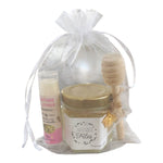 Cadeau personnalisé Joyeuses Fêtes avec mini pot de miel artisanal, baume à lèvres à la cire de nos abeilles, cuillère à miel en bois, breloque abeille et pochon en organza.