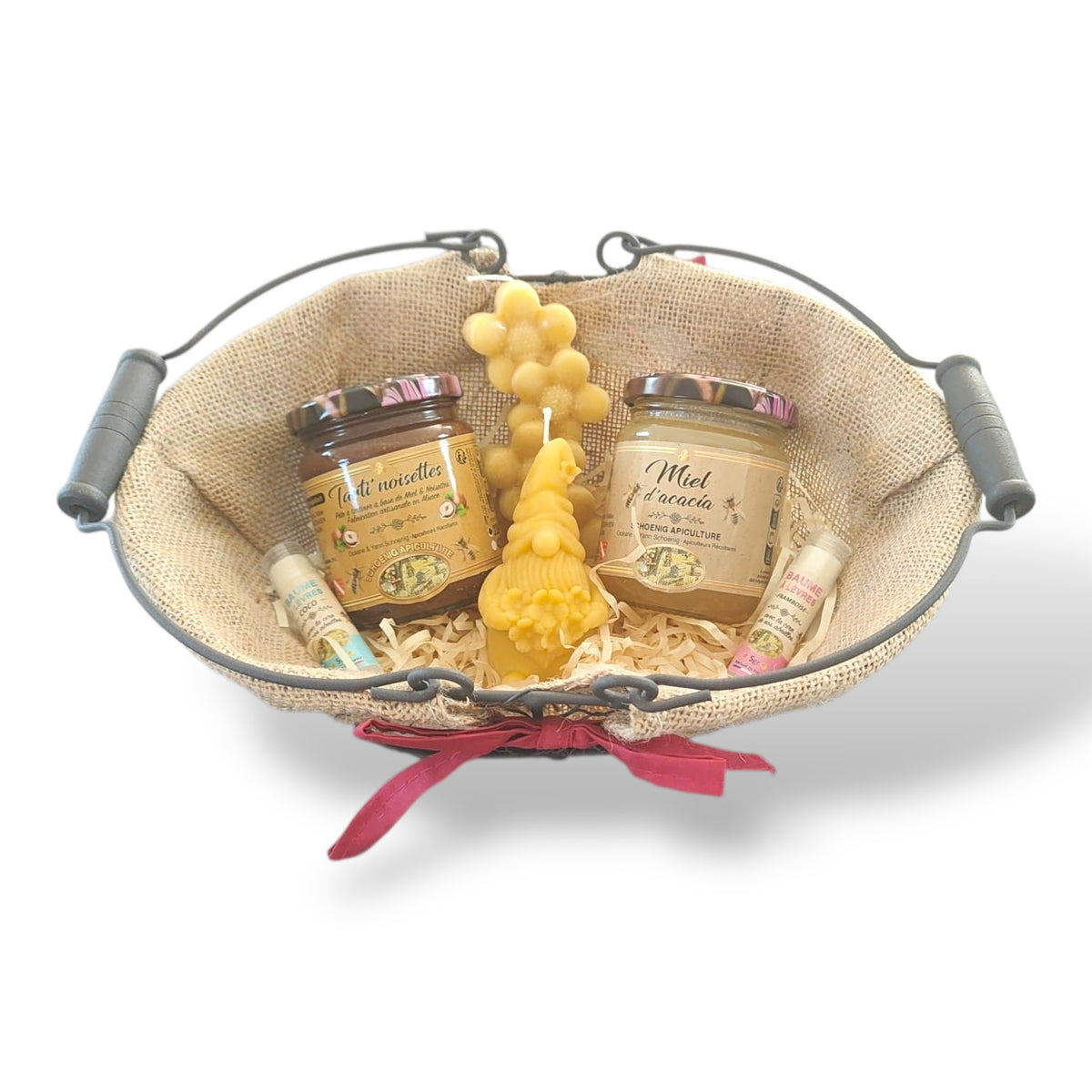 Panier cadeau artisanal avec miel naturel, bougie en cire d’abeille et baume à lèvres, présenté dans un panier rustique, idée cadeau Pâques authentique et écologique.