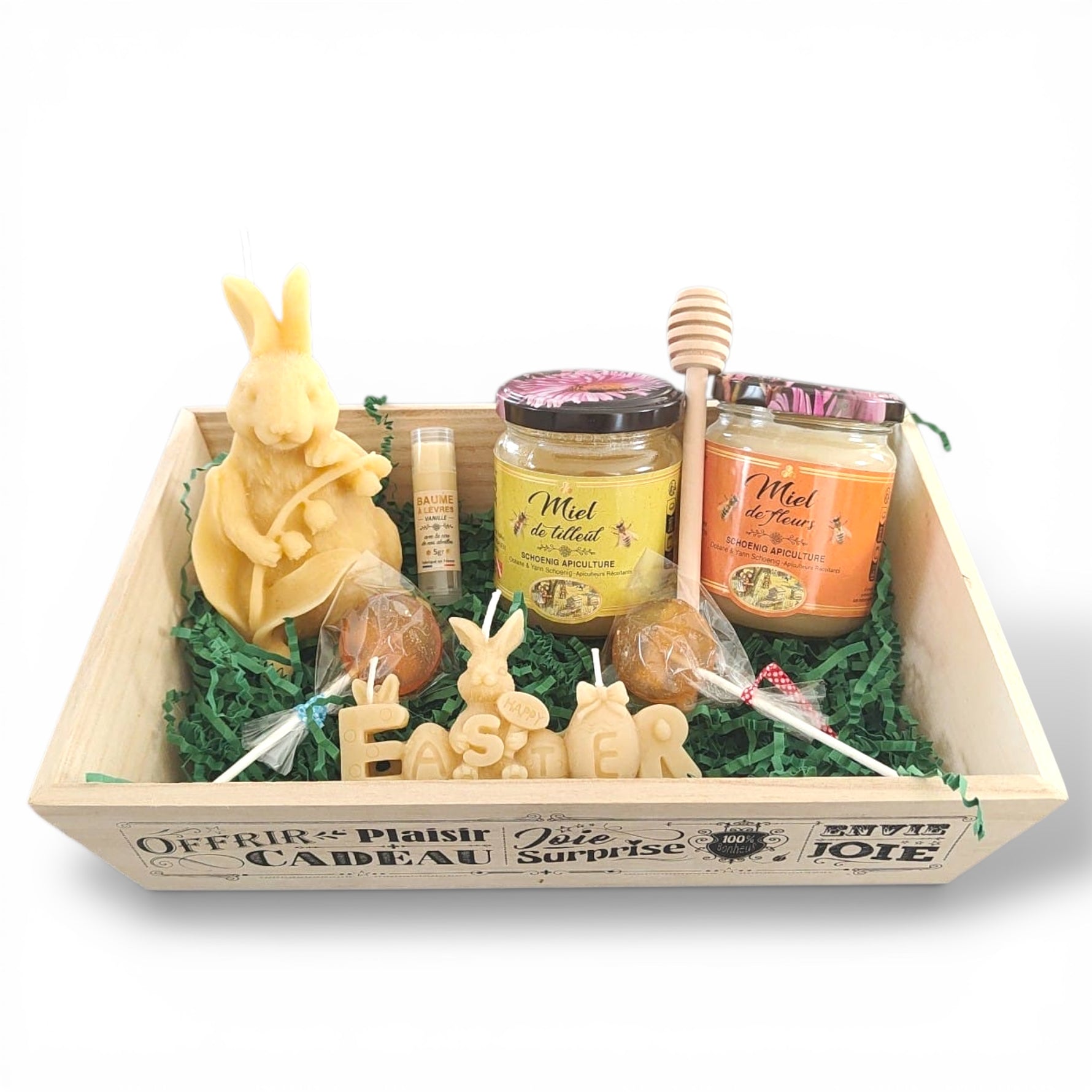 Coffret cadeau artisanal avec miel, bougies en cire d’abeille, sucettes au miel, baume à lèvres naturel et cuillère à miel en bois, présenté dans un plateau en bois, idée cadeau originale et gourmande.