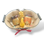 Panier cadeau artisanal avec miel naturel, bougie en cire d’abeille et baume à lèvres, présenté dans un panier rustique, idée cadeau Pâques authentique et écologique.