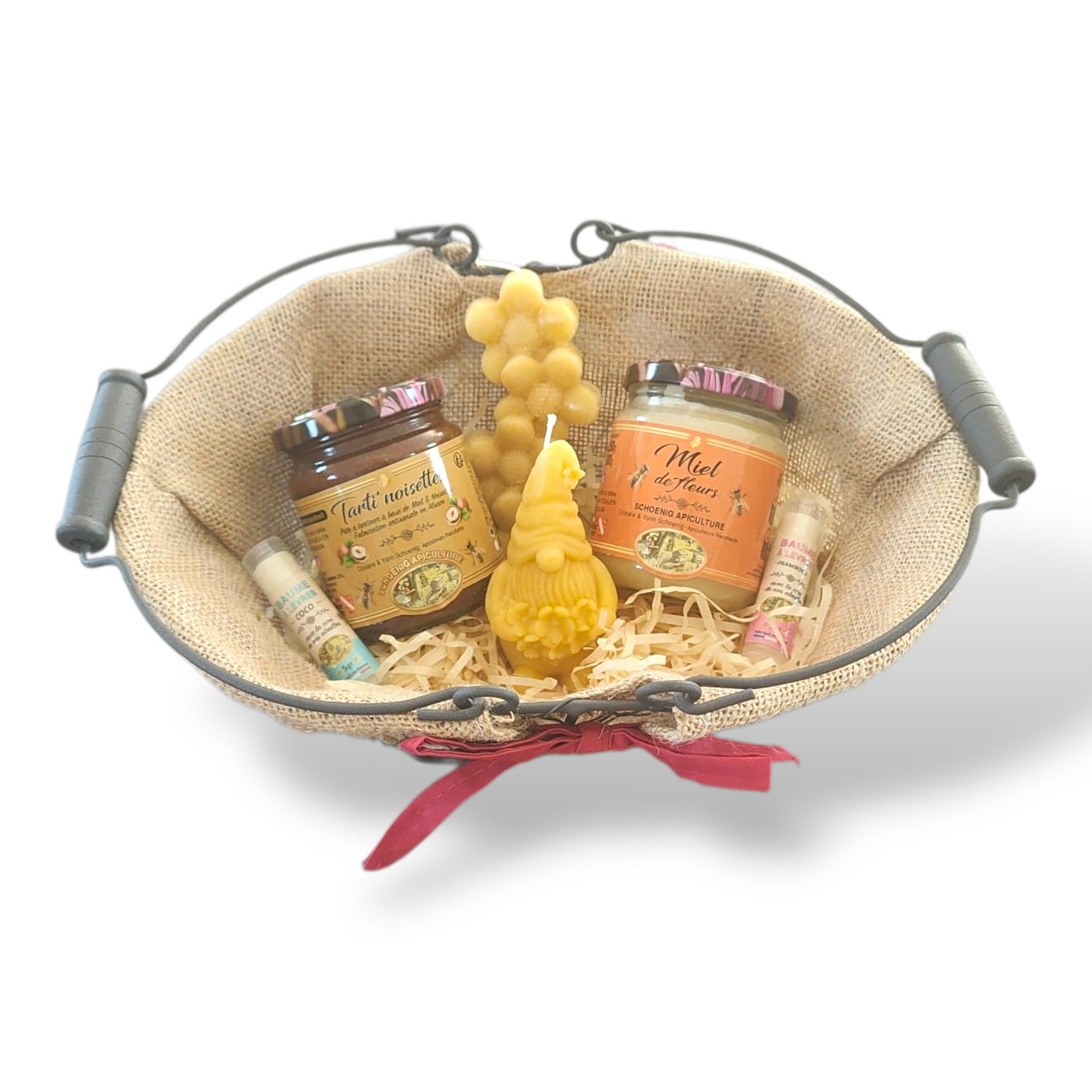Panier cadeau artisanal avec miel naturel, bougie en cire d’abeille et baume à lèvres, présenté dans un panier rustique, idée cadeau Pâques authentique et écologique.