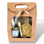 Coffret cadeau invité baptême garçon personnalisé avec pot de miel artisanal bleu, bougie en cire d’abeille représentant des mains tenant des pieds de bébé et cuillère à miel, présenté dans une boîte kraft.