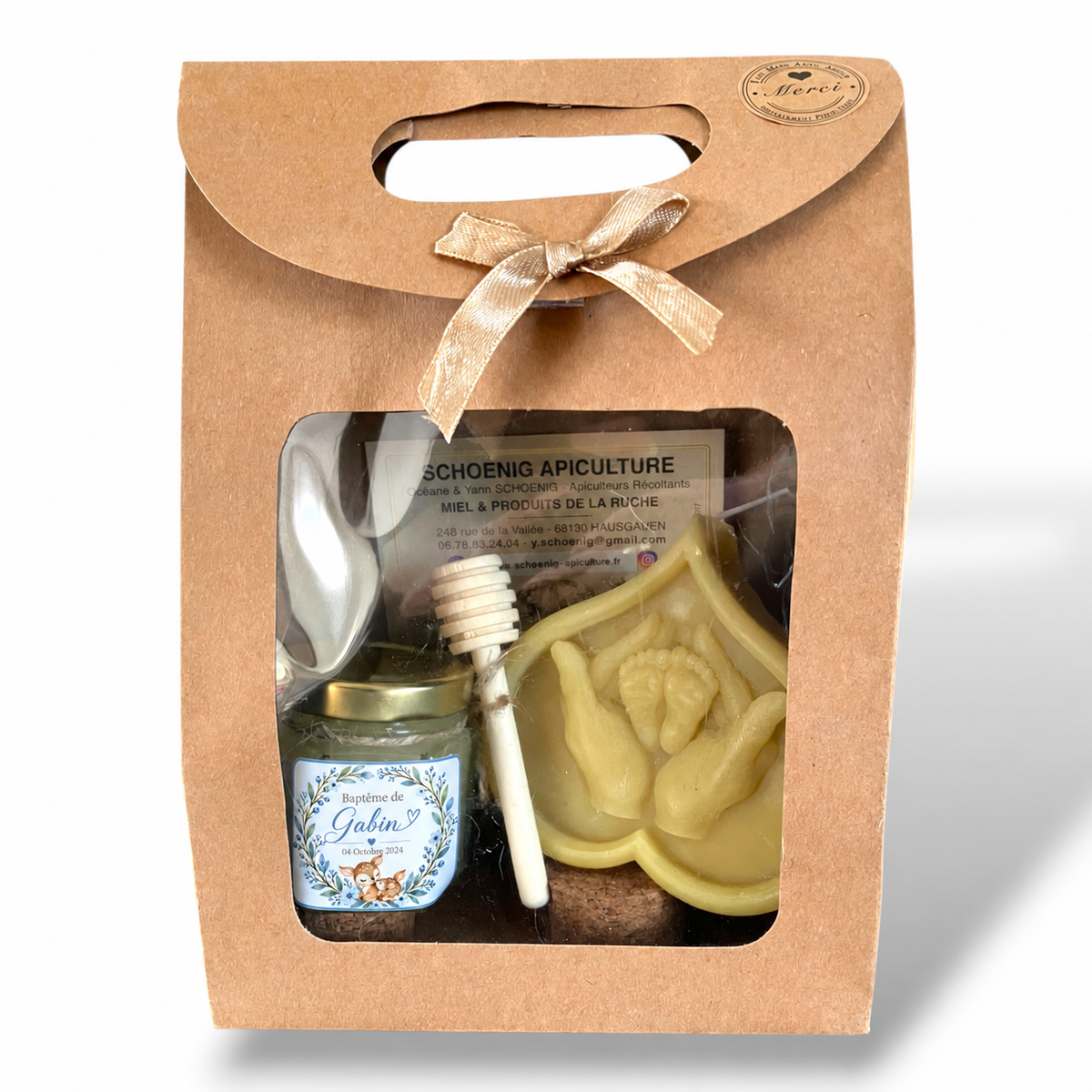 Coffret cadeau invité baptême garçon personnalisé avec pot de miel artisanal bleu, bougie en cire d’abeille représentant des mains tenant des pieds de bébé et cuillère à miel, présenté dans une boîte kraft.