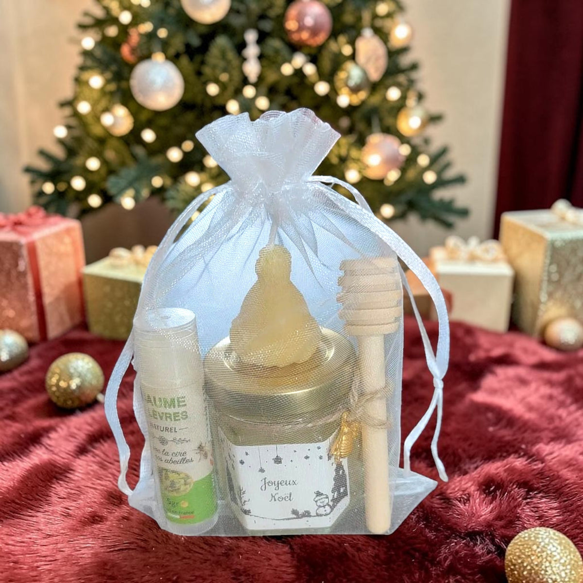 Cadeau de Noël personnalisé composé d'un mini pot de miel, d'un baume à lèvres artisanal, d'une bougie en cire d'abeille et d'une cuillère à miel, idéal pour un cadeau de fin d'année ou de remerciement.