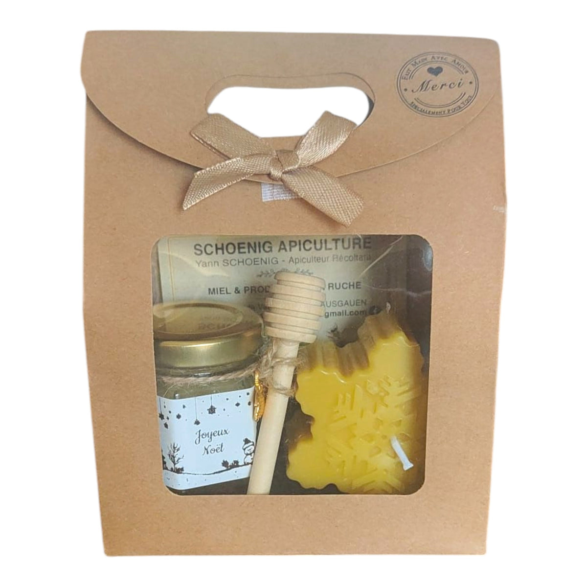 Coffret cadeau de Noël avec bougie artisanale en forme de flocon, pot de miel et cuillère à miel.