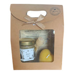 Coffret cadeau artisanal de Noël avec miel de nos ruches, bougie en cire d'abeille en forme de cœur et cuillère à miel, prêt à offrir.