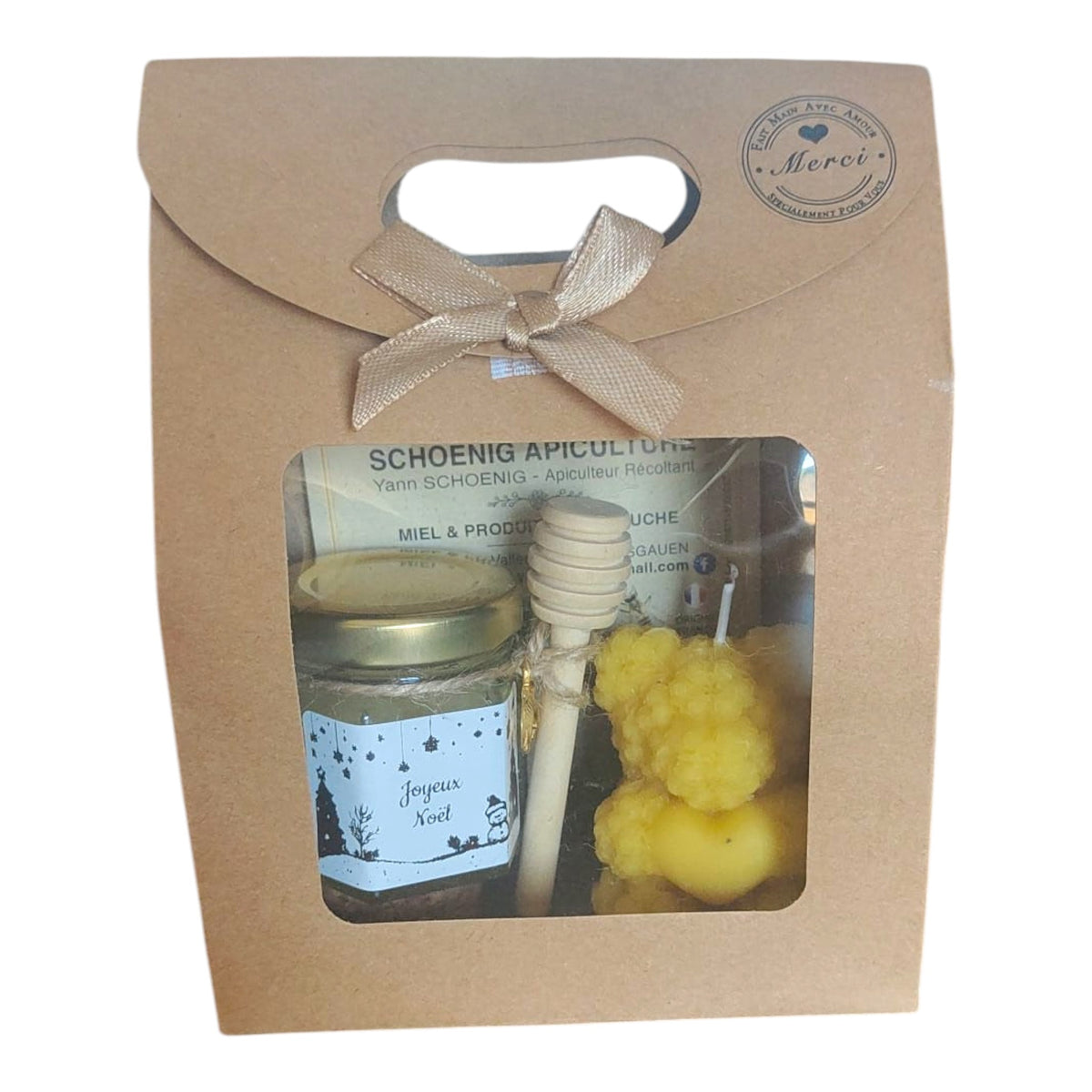 Petit coffret cadeau de Noël comprenant un pot de miel artisanal, une bougie en cire d'abeille en forme d'ourson et une cuillère à miel en bois.