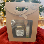 Coffret cadeau de Noël personnalisé présenté en mise en scène festive avec mini pot de miel artisanal, baume à lèvres à la cire d'abeille et emballage kraft prêt à offrir.