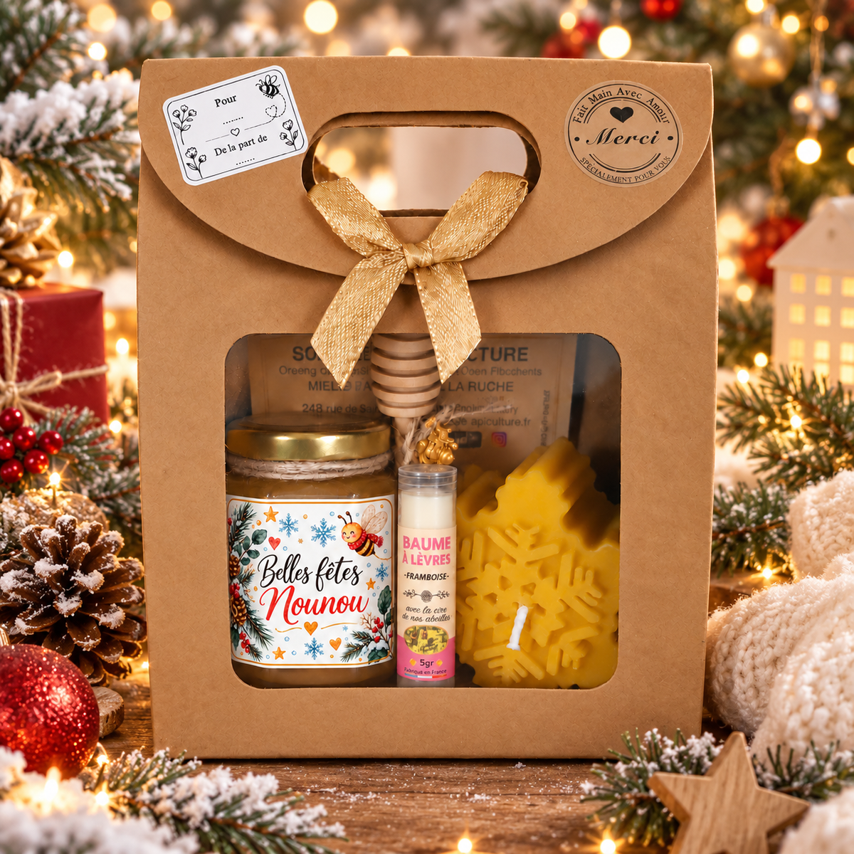 Coffret cadeau Nounou artisanal présenté dans une ambiance de Noël hivernale avec miel, baume à lèvres et bougie en cire d’abeille