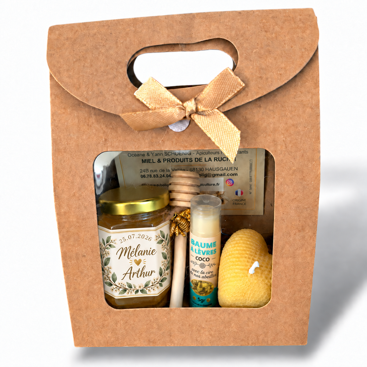 Coffret invité mariage artisanal contenant un pot de miel personnalisé, un baume à lèvres coco et une bougie cœur gaufré en cire d’abeille.