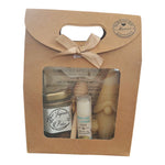 Coffret cadeau artisanal avec miel, baume coco, bougie lutin en cire d'abeille et étiquette Joyeuses Fêtes.