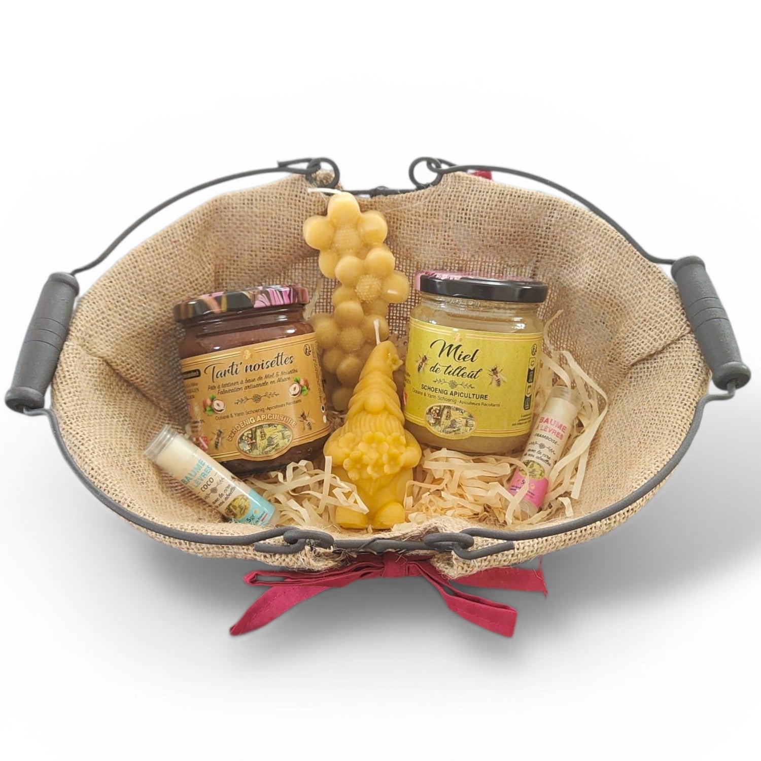 Panier cadeau artisanal avec miel naturel, bougie en cire d’abeille et baume à lèvres, présenté dans un panier rustique, idée cadeau authentique et écologique.